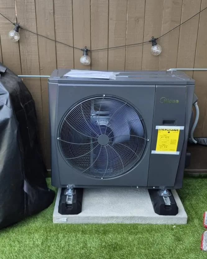 Compact outdoor unit on a pad in a backyard